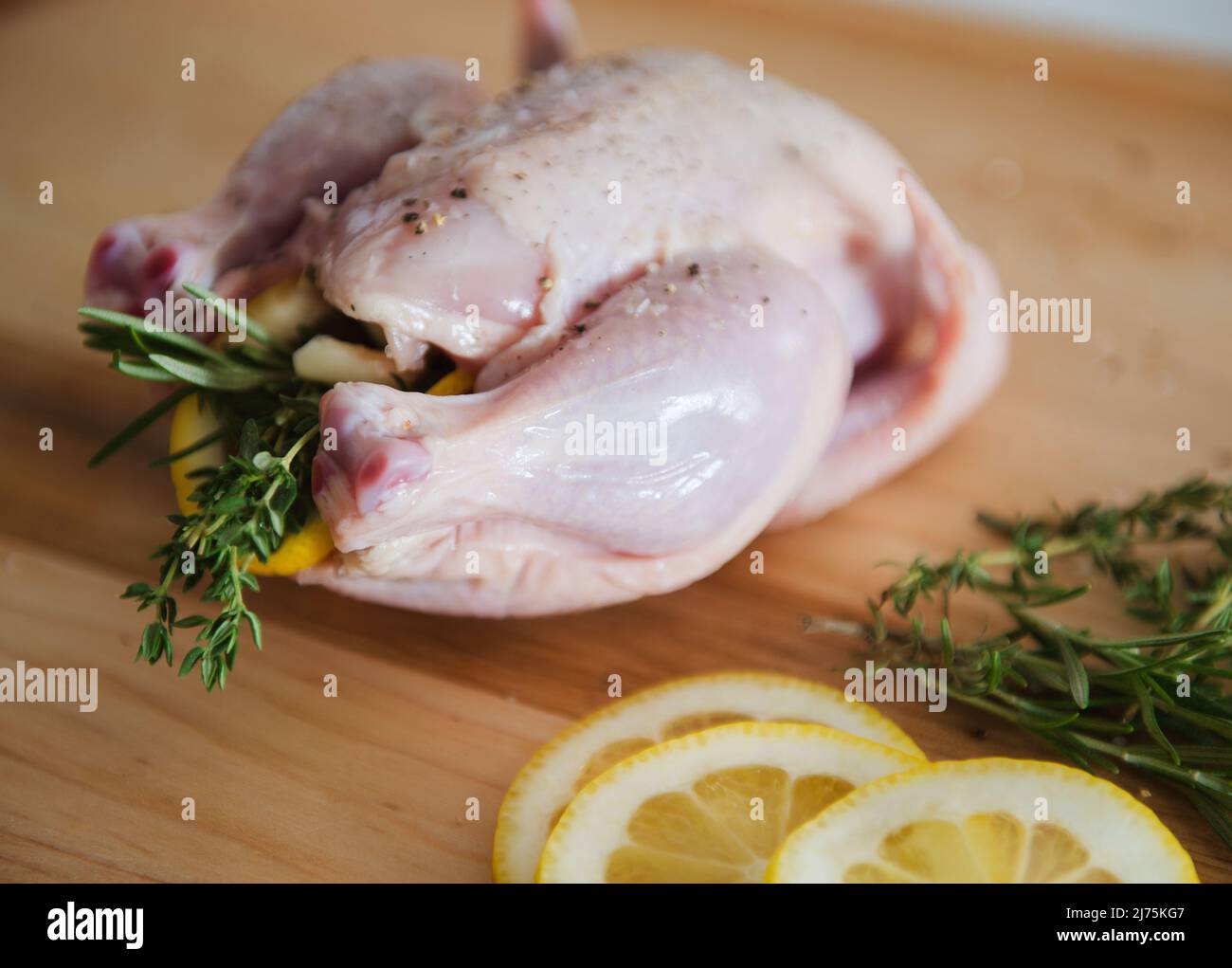 Raw Game Hen Stuffed with Lemon, Rosemary and Thyme Stock Photo