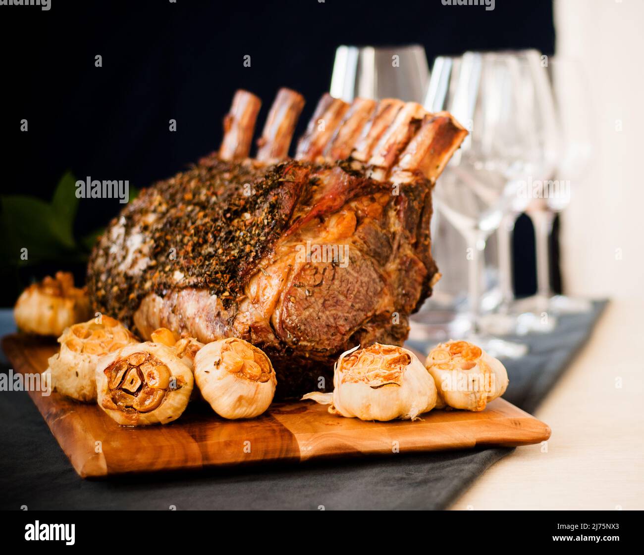 Dry Aged Frenched Prime Rib Roast with Whole Bulbs of Garlic Stock Photo