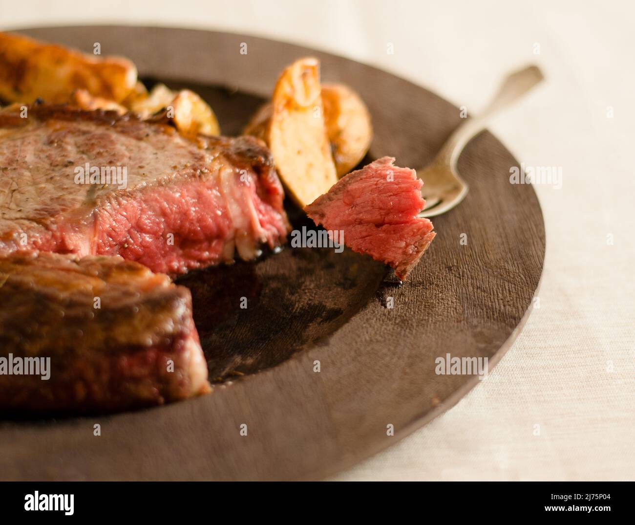 Dry Aged Prime Rib Chop Cooked Rare with a Piece Pierced on a Fork Stock Photo