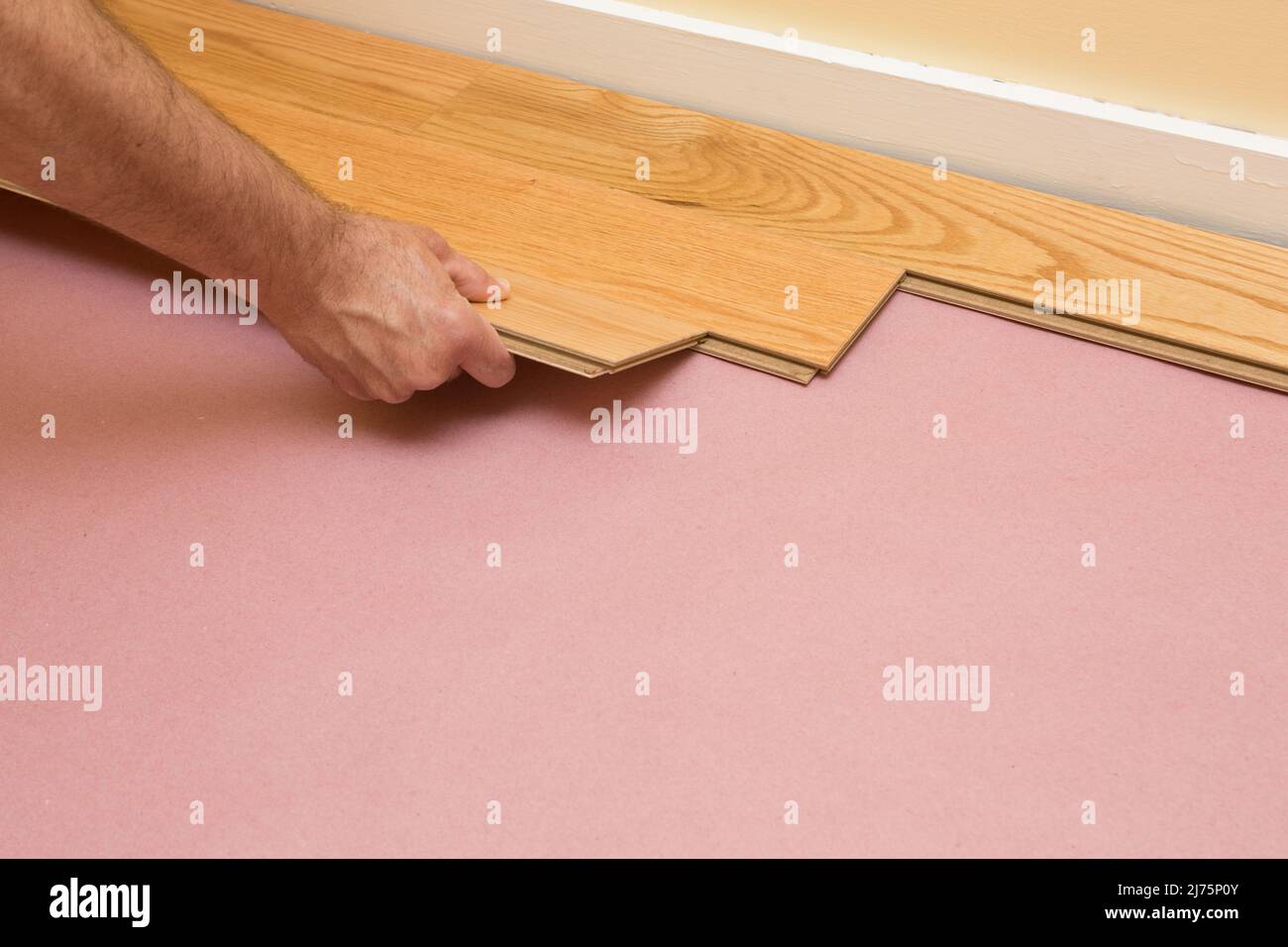Series of shots of engineered hardwood floor being installed by a