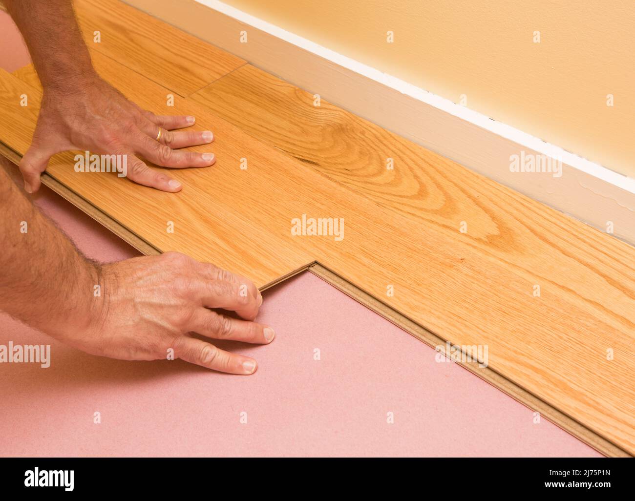 Series of shots of engineered hardwood floor being installed by a