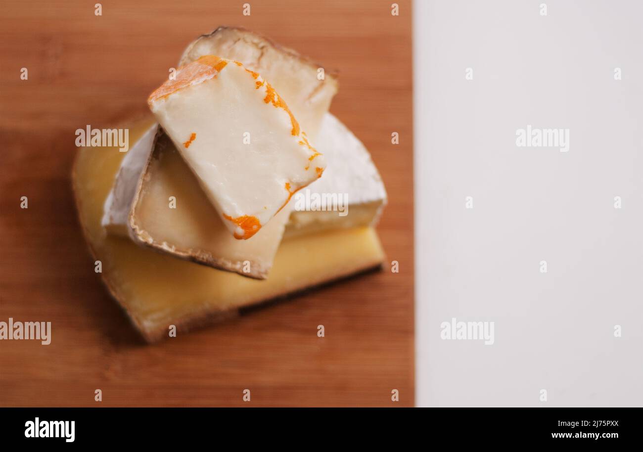 Four Assorted French Cheeses Stacked on a Board Stock Photo