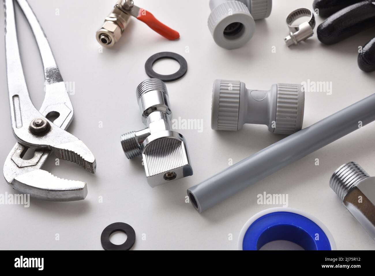 Detail of group of plumbing equipment on white workbench. Elevated view. Horizontal composition. Stock Photo