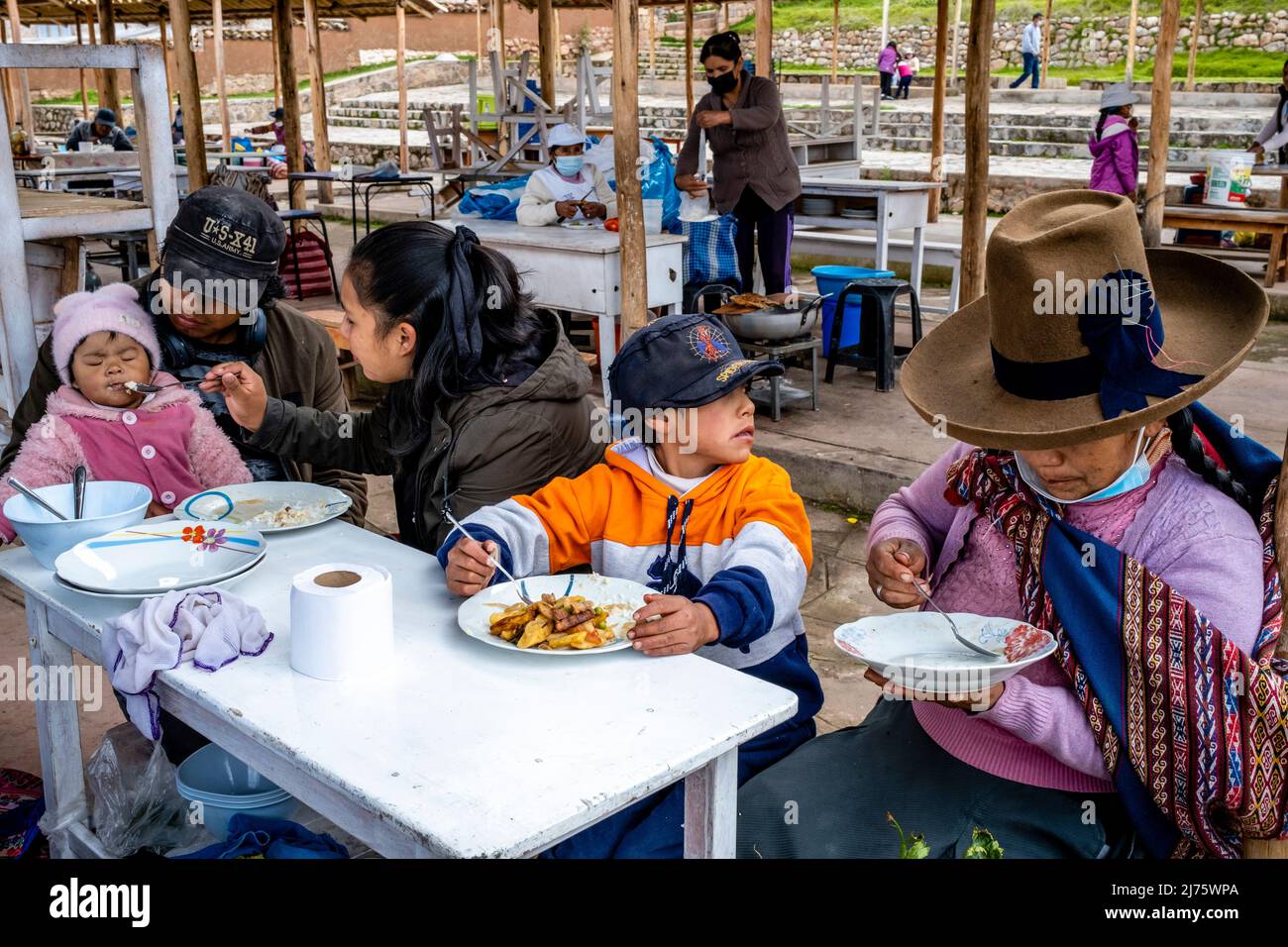 A Peruvian Family Eating A Meal At The Sunday Market In The Village Of Chinchero, The Sacred Valley, Urubamba Province, Peru. Stock Photo