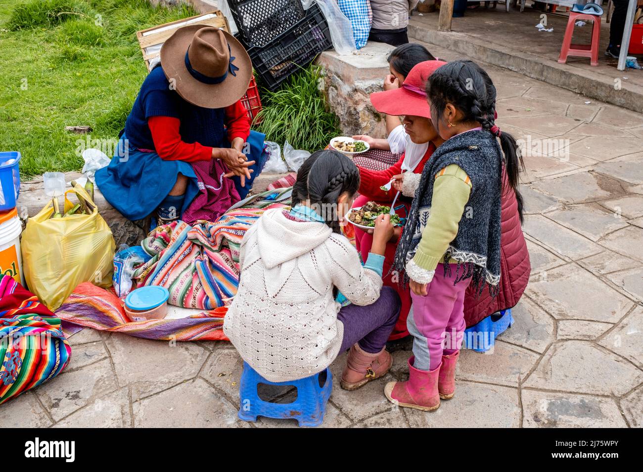 A Peruvian Family Eating A Meal At The Sunday Market In The Village Of Chinchero, The Sacred Valley, Urubamba Province, Peru. Stock Photo