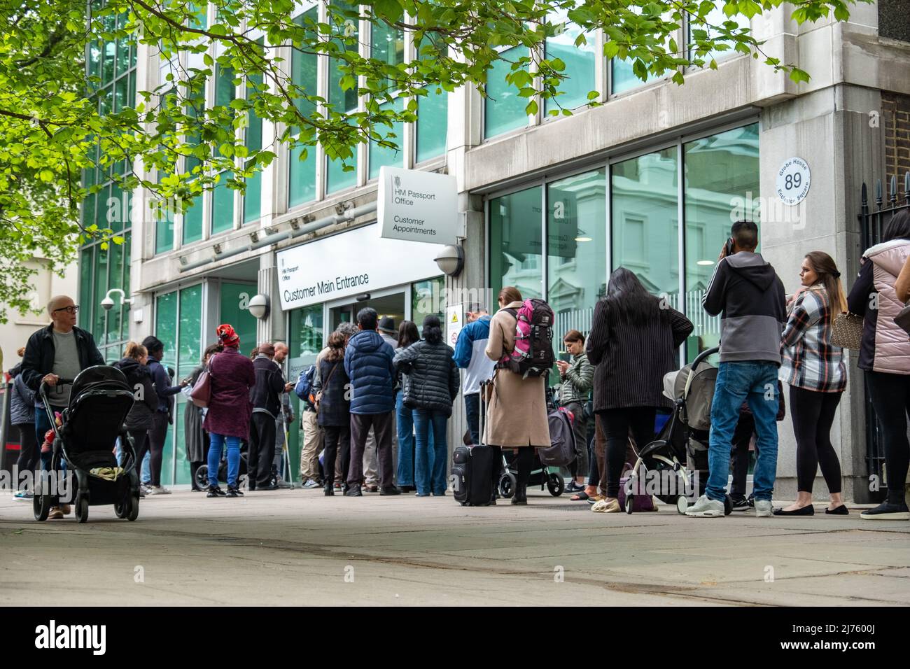 London, Victoria- May 2022: People queueing at Her Majesty's Passport Office due to delays and high processing times Stock Photo