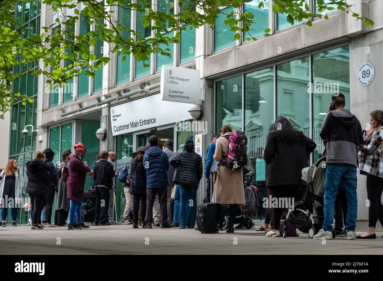 London, Victoria- May 2022: People queueing at Her Majesty's Passport Office due to delays and high processing times Stock Photo