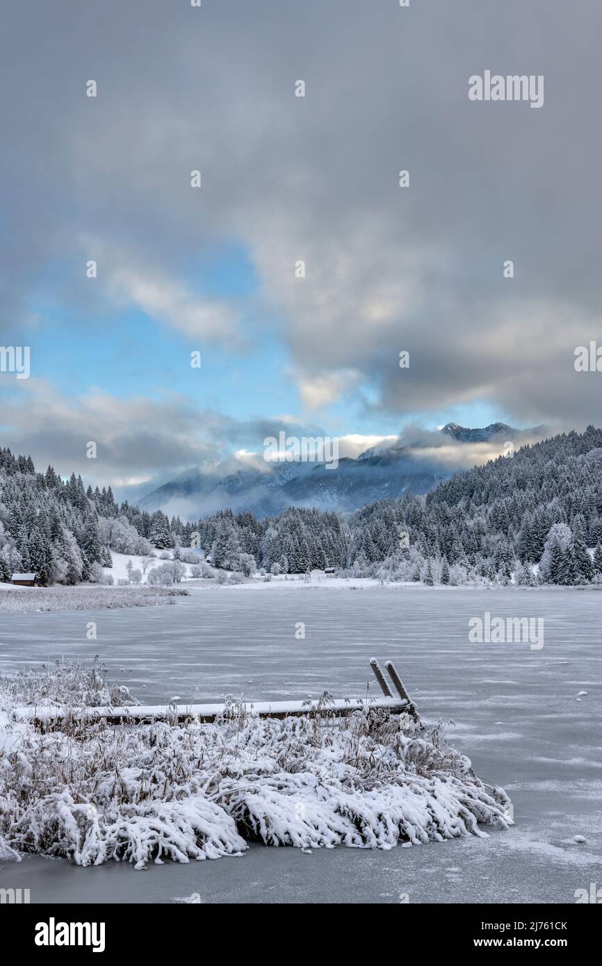 The bathing jetty at Geroldsee in winter, in the background the Soierngruppe and dense clouds with fog Stock Photo