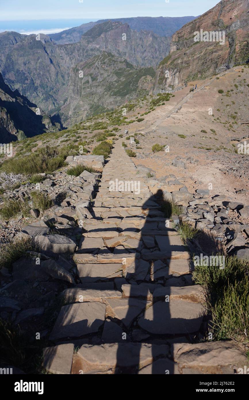 Shadow of a female hiker taking picture on the rural hiking trail from Pico Ruivo to Pico Arieiro in Madeira, Portugal, Europe. Photo by Matheisl Stock Photo