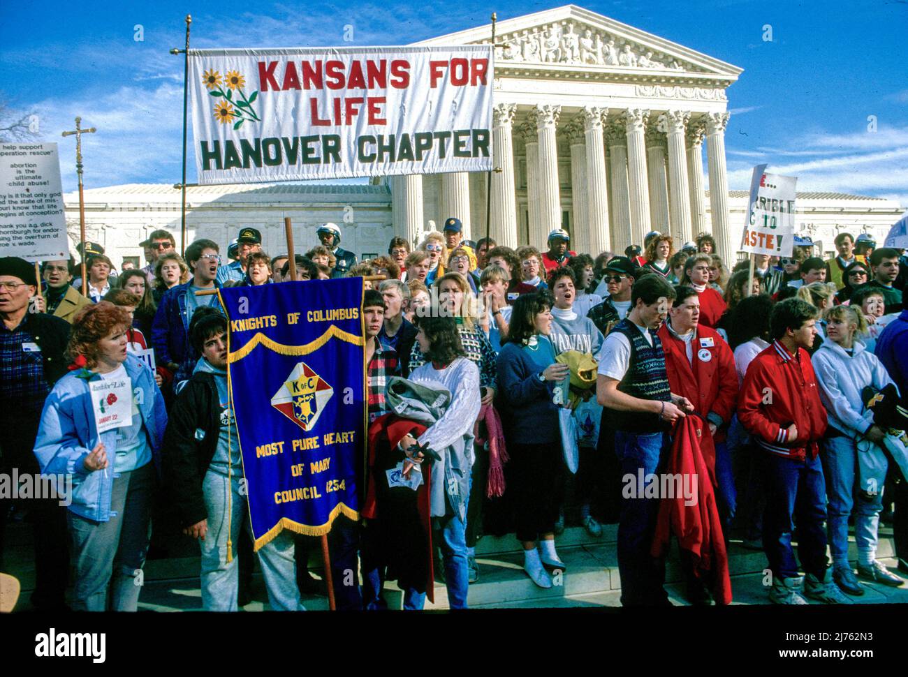 View of anti-abortion demonstrators, many with signs, as they pose in front of the United States Supreme Court Building during the annual March for Life, Washington DC, January 22, 1989. Among the visible signs is a banner that reads 'Kansans for Life.' (Photo by Mark Reinstein/Corbis via Getty Images) Stock Photo