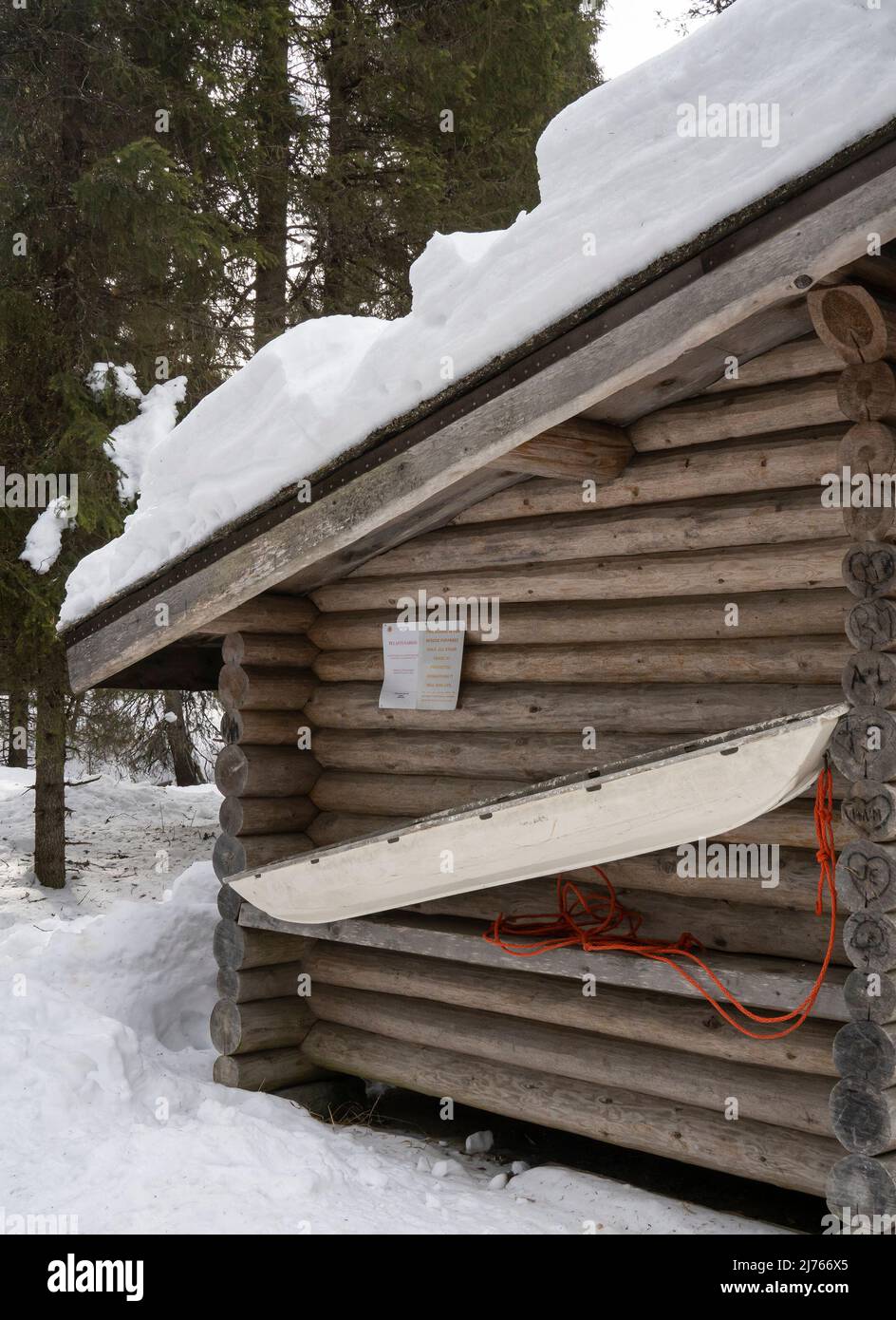 Rovaniemi, Finland - March 19th, 2022: A rescue sledge on the wall of a log cabin in a snowy forest in Finland. Stock Photo