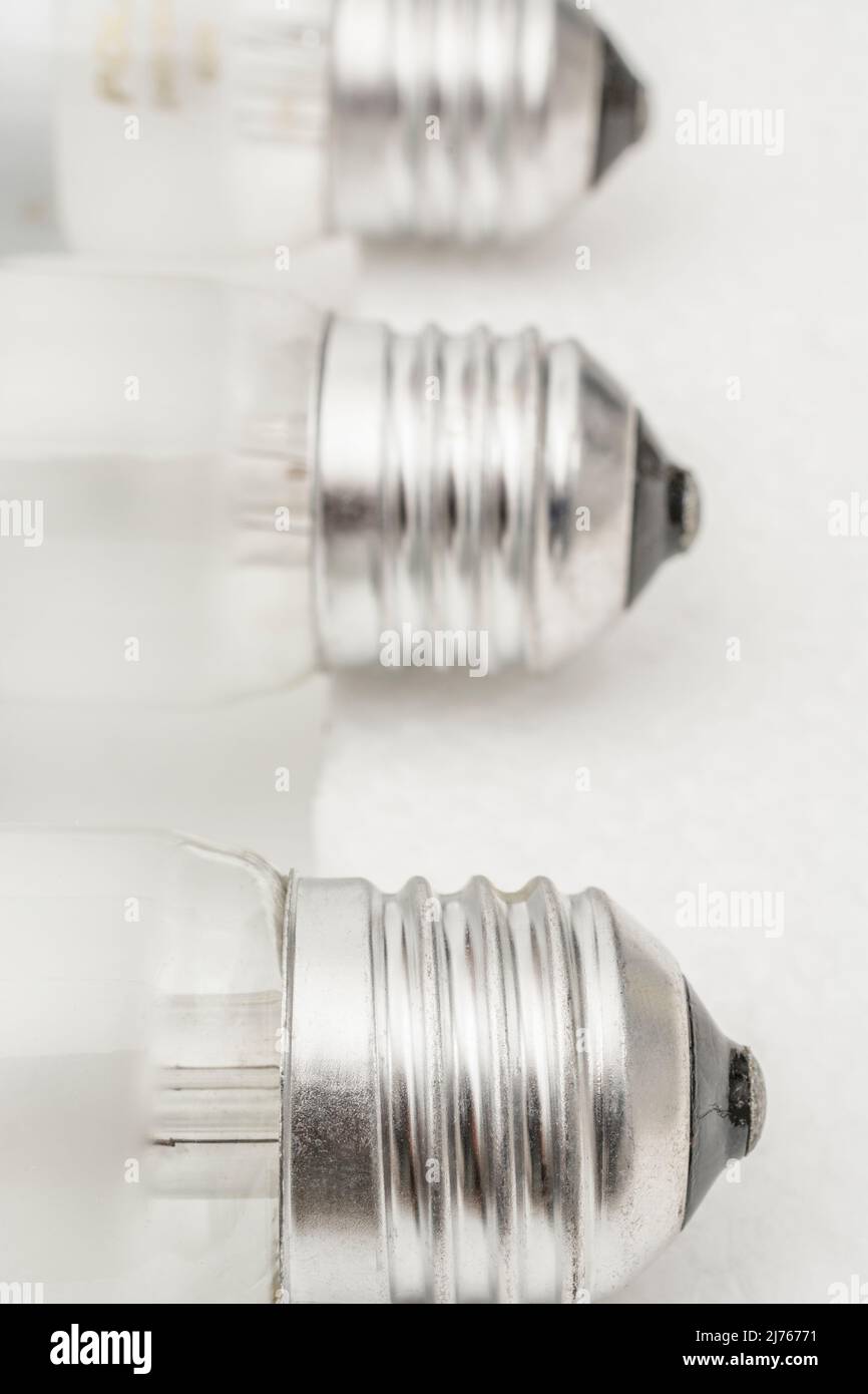 Close shot of glass incandescent light bulb cap with E27 / Edison Screw 27mm thread fitting. For illuminating, UK lighting industry, lighting abstract Stock Photo