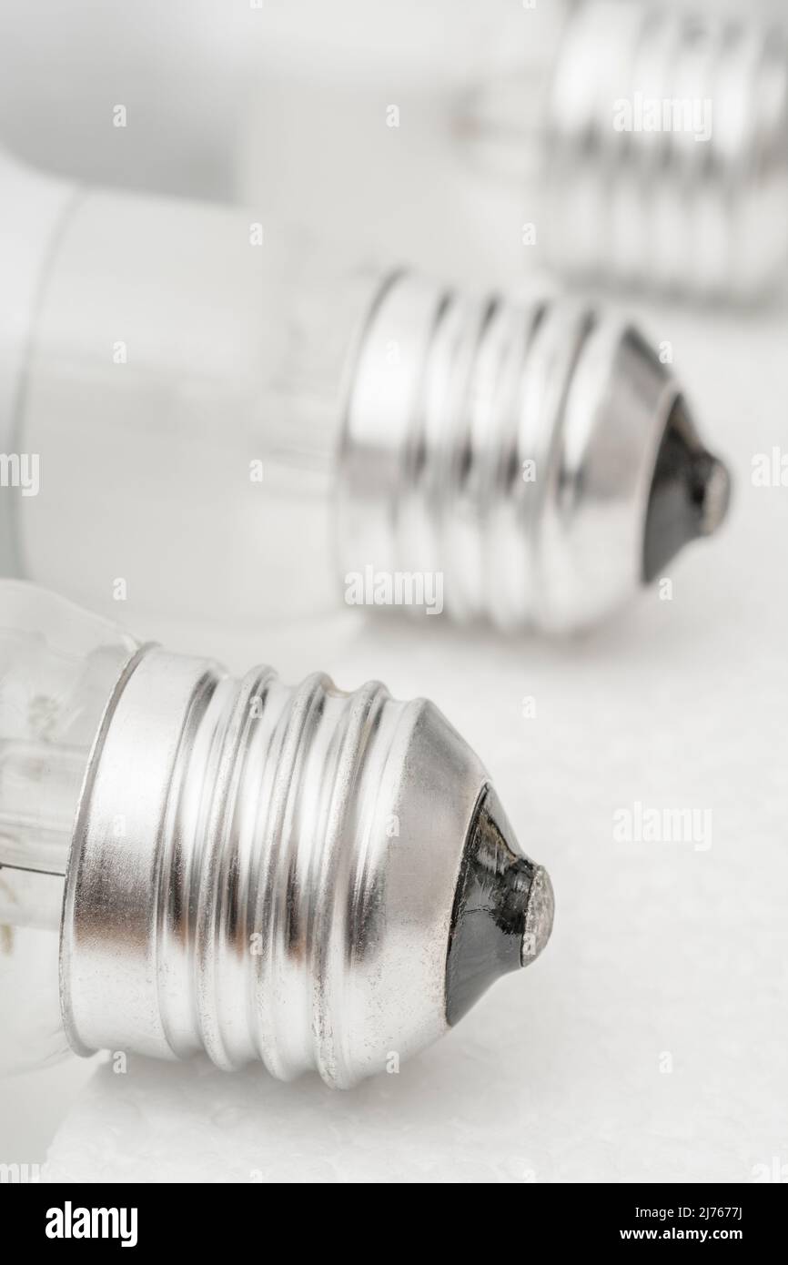 Close shot of glass incandescent light bulb cap with E27 / Edison Screw 27mm thread fitting. For illuminating, UK lighting industry, lighting abstract Stock Photo