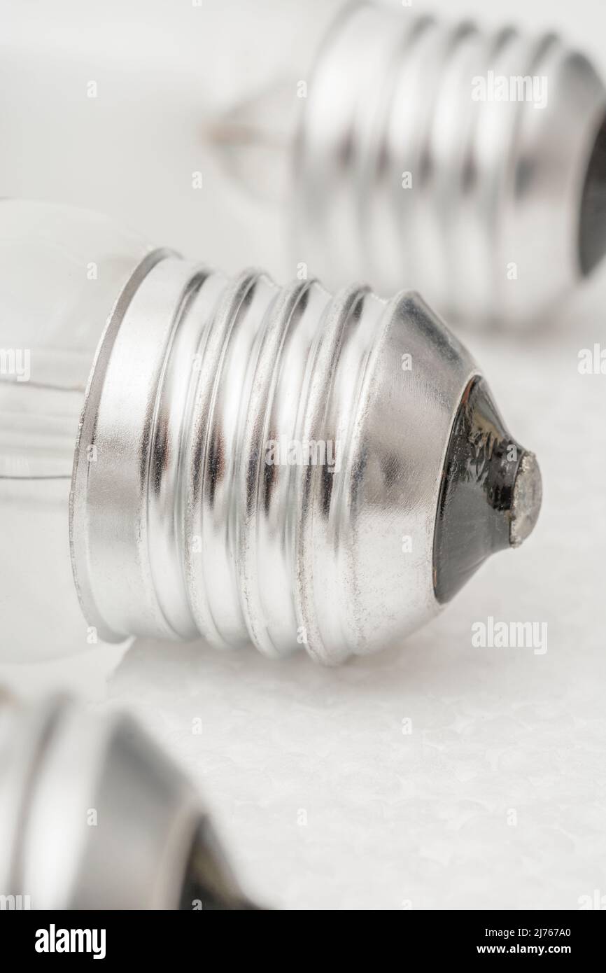 Close shot of glass incandescent light bulb cap with E27 / Edison Screw 27mm thread fitting. For illuminating, UK lighting industry, lighting abstract Stock Photo