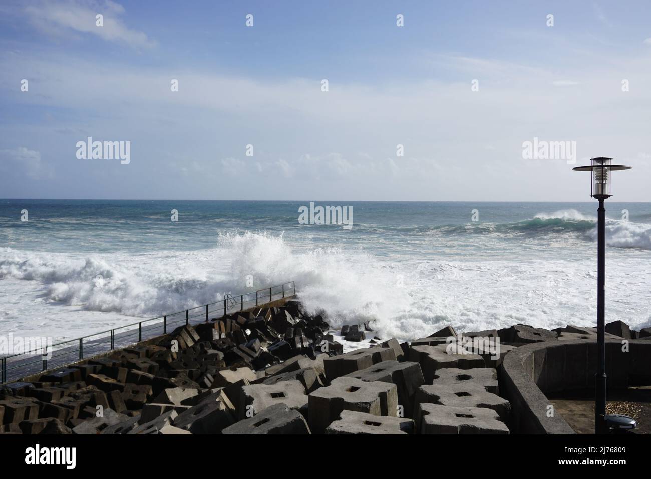 Breaking waves and concrete sea defence blocks. Atlantic Ocean at the seafront promenade in Jardim do Mar, madeira, Portugal, Europe. Photo Matheisl Stock Photo