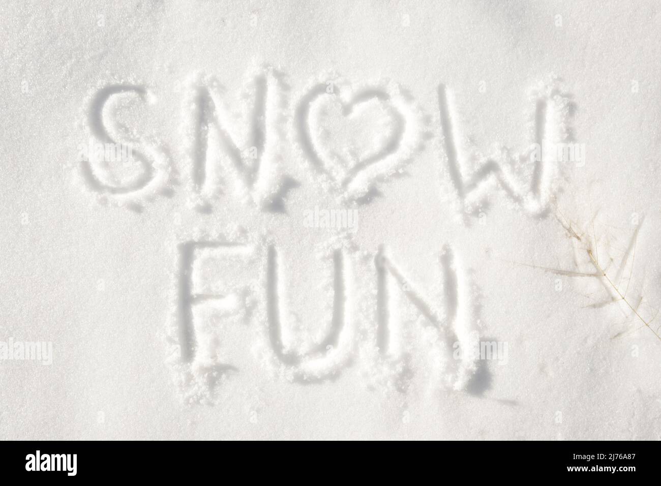 Words 'snow fun' with a heart for letter o written in snow; concept of fun that can be had on a snowy winter day Stock Photo