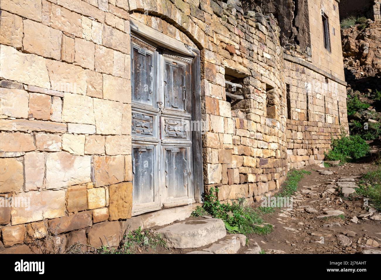 Old door of an abandoned house in the mountain village of Gamsutl on a sunny morning. Republic of Dagestan, Russian Federation Stock Photo