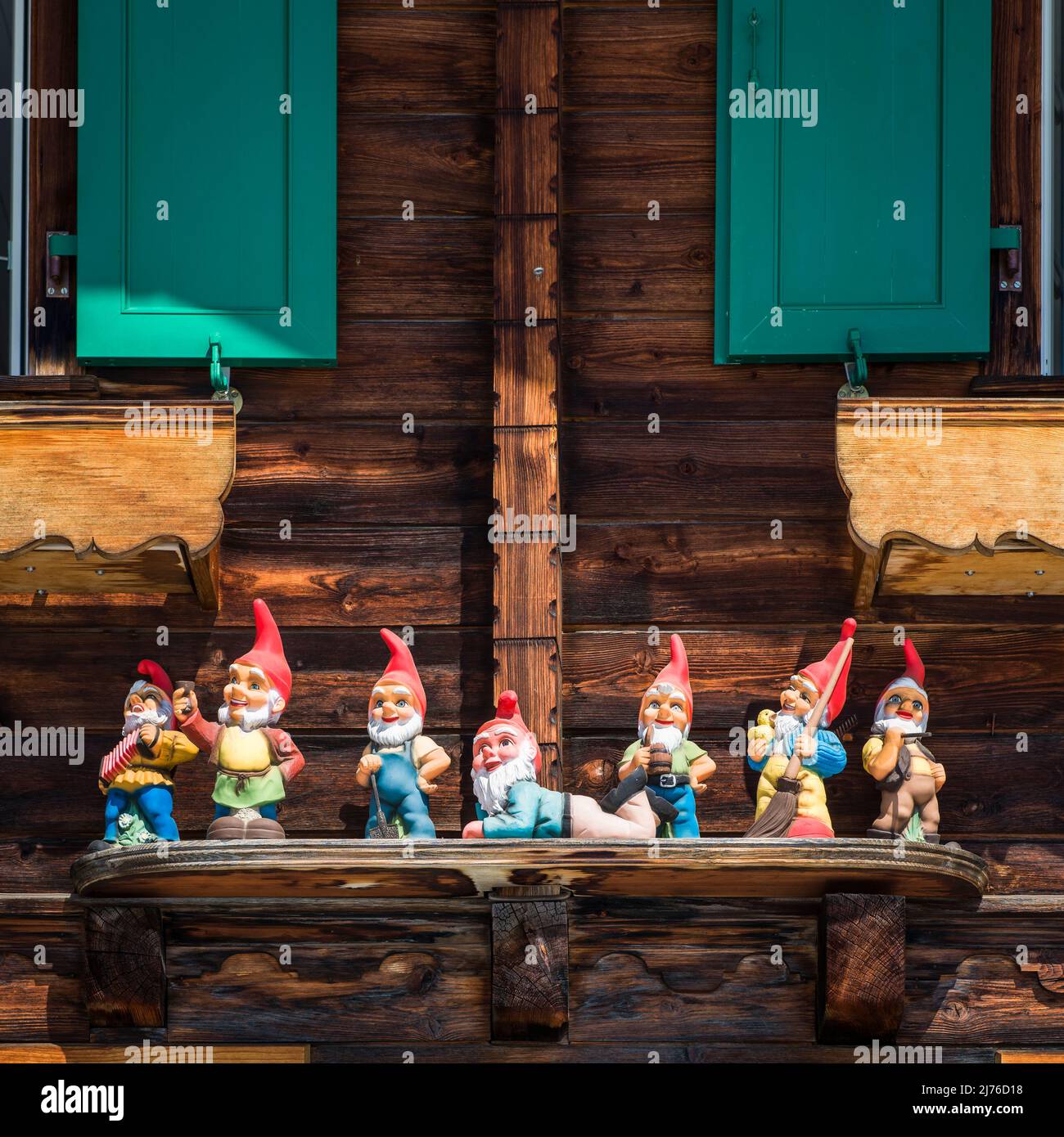 Garden gnomes in front of a wooden house, facade decoration Stock Photo