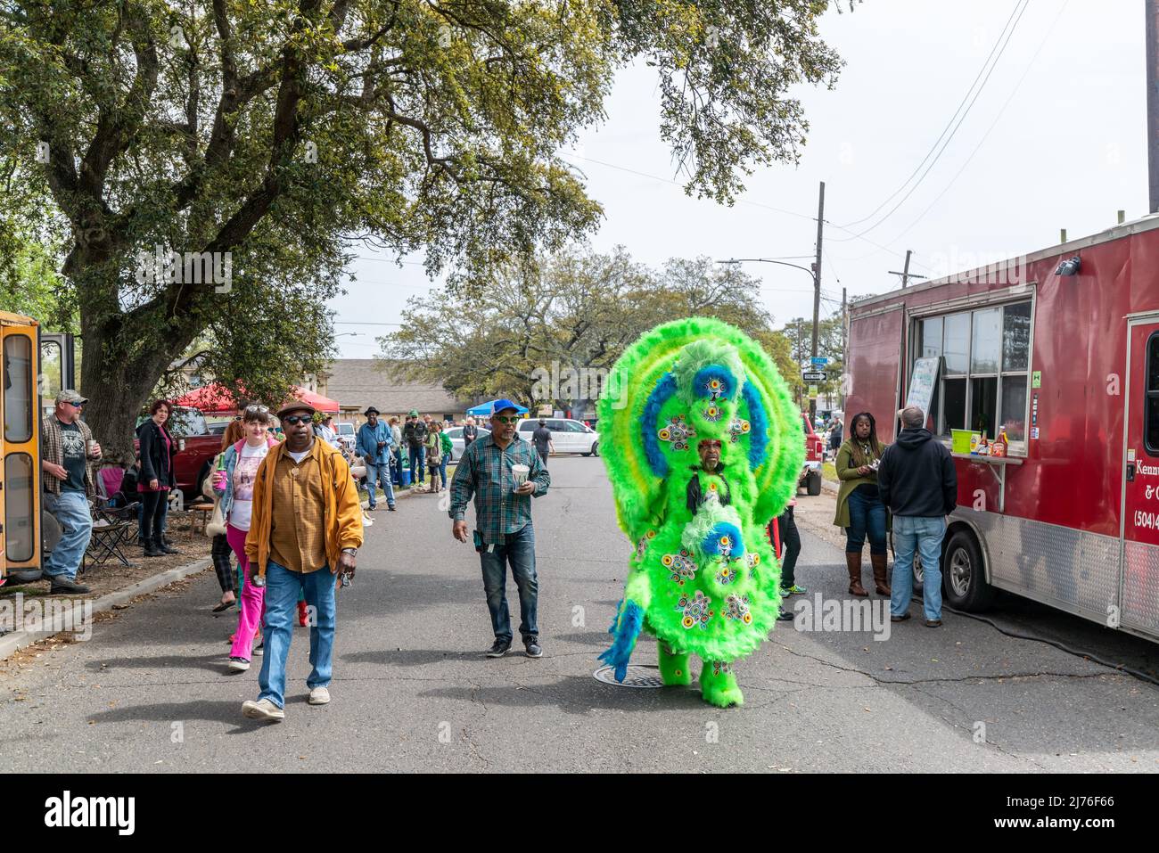 NEW ORLEANS, LA, USA - MARCH 17, 2019: People, including a Mardi Gras Indian, walking past a food truck on LaSalle Street on Super Sunday Stock Photo