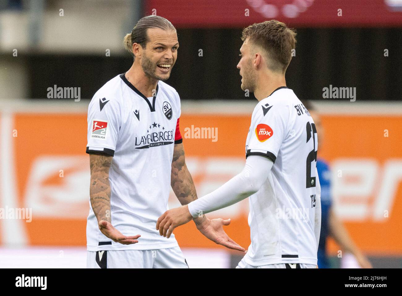 06 May 2022, North Rhine-Westphalia, Paderborn: Soccer: 2. Bundesliga, SC Paderborn 07 - SV Sandhausen, Matchday 33, Benteler-Arena: Sandhausen's Dennis Diekmeier (l) scolds Sandhausen's Tom Trybull after scoring the 2-0 goal. Photo: David Inderlied/dpa - IMPORTANT NOTE: In accordance with the requirements of the DFL Deutsche Fußball Liga and the DFB Deutscher Fußball-Bund, it is prohibited to use or have used photographs taken in the stadium and/or of the match in the form of sequence pictures and/or video-like photo series. Stock Photo