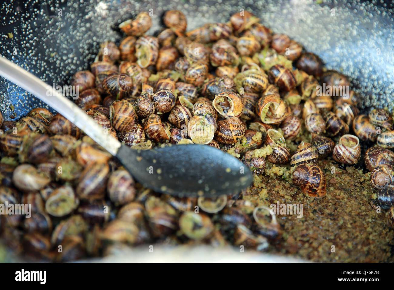 Snails being cooked in garlic butter at a French Market. Stock Photo