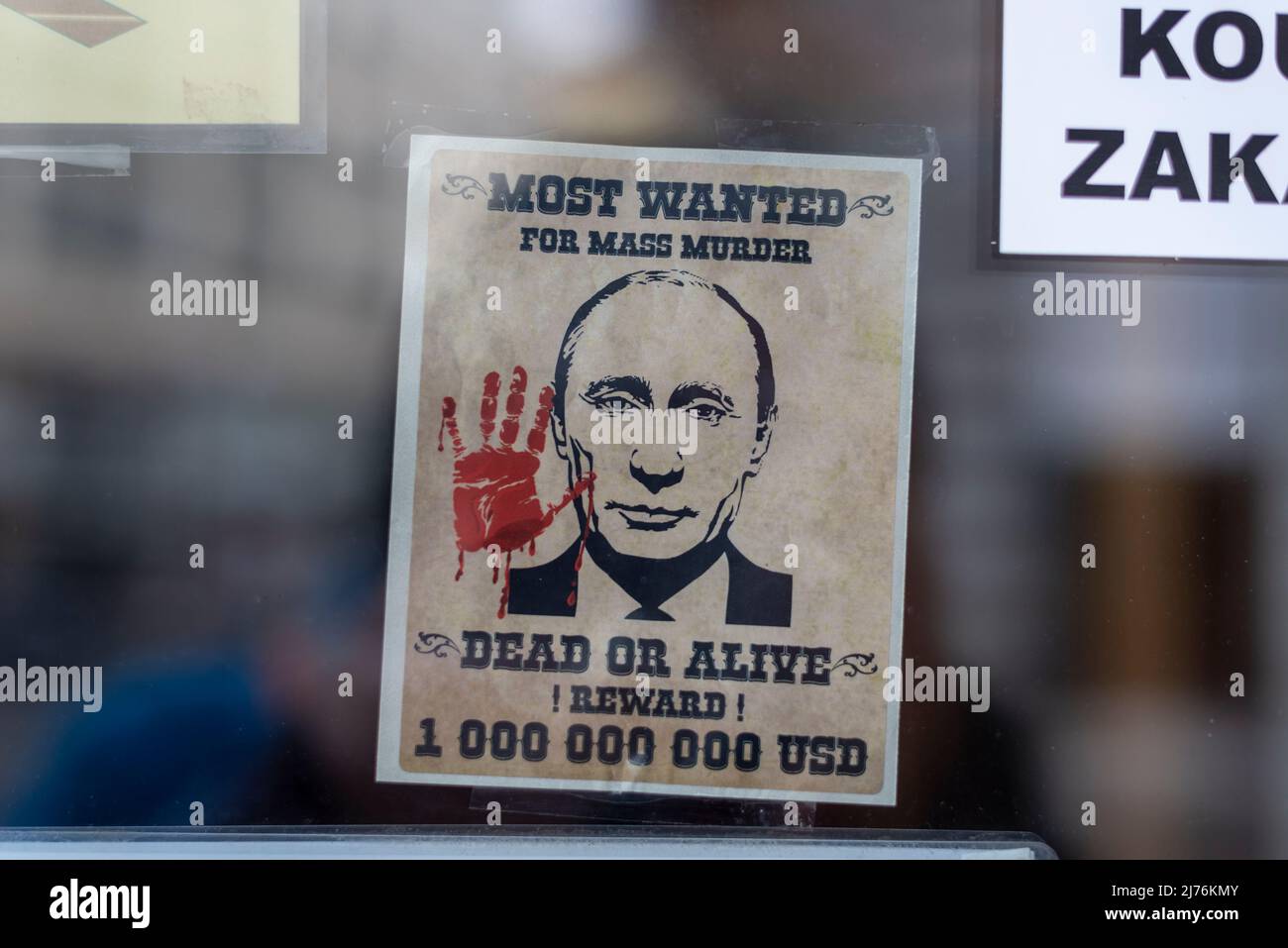 In the window of a restaurant in Prague hangs a wanted poster depicting Russian President Vladimir Putin. Stock Photo