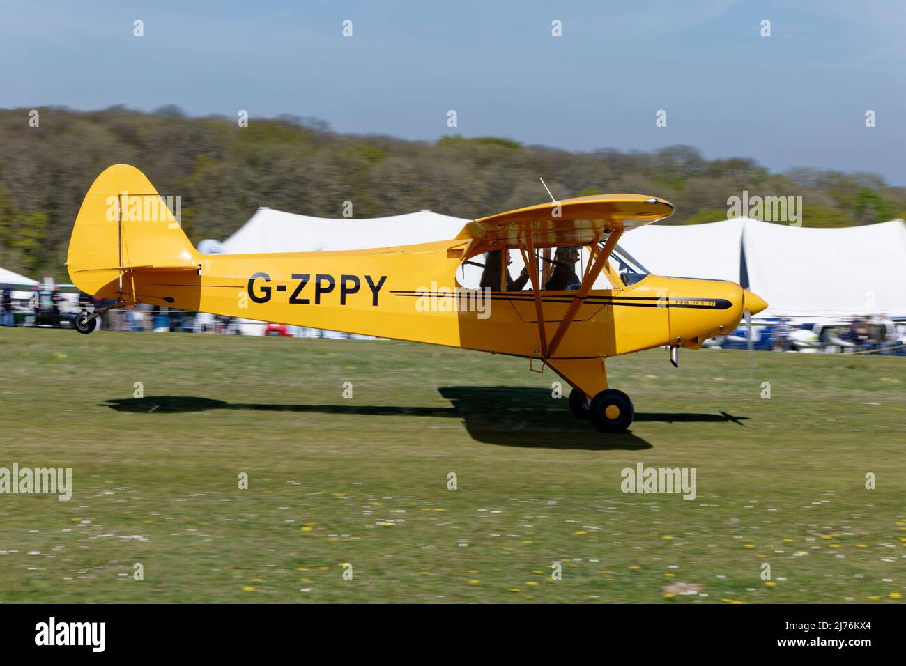 Built in 1953 this smart yellow Piper PA18 Super Cub G-ZPPY is looking in tip top condition as it starts its take off roll to depart Popham airfield Stock Photo