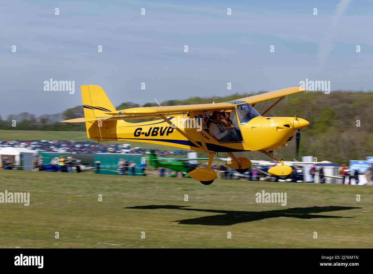 Bright Yellow  Eurofox microlight airplane G-JBVP arrives at Popham airfield in Hampshire England to attend the annual microlight aircraft fly-in Stock Photo