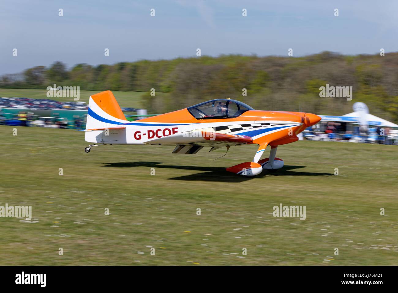 Beautiful Orange & White Vans RV-6 taildragger airplane G-DCOE arrives at Popham airfield in Hampshire England to attend the annual microlight fly-in Stock Photo