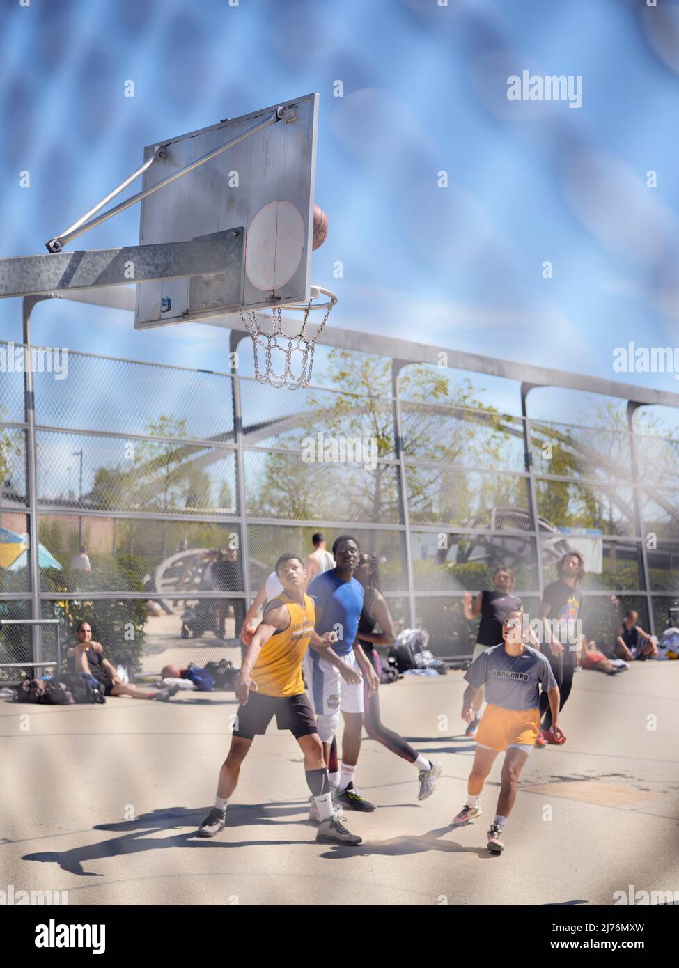 Basketball players in the harbor park in Frankfurt look after the throw