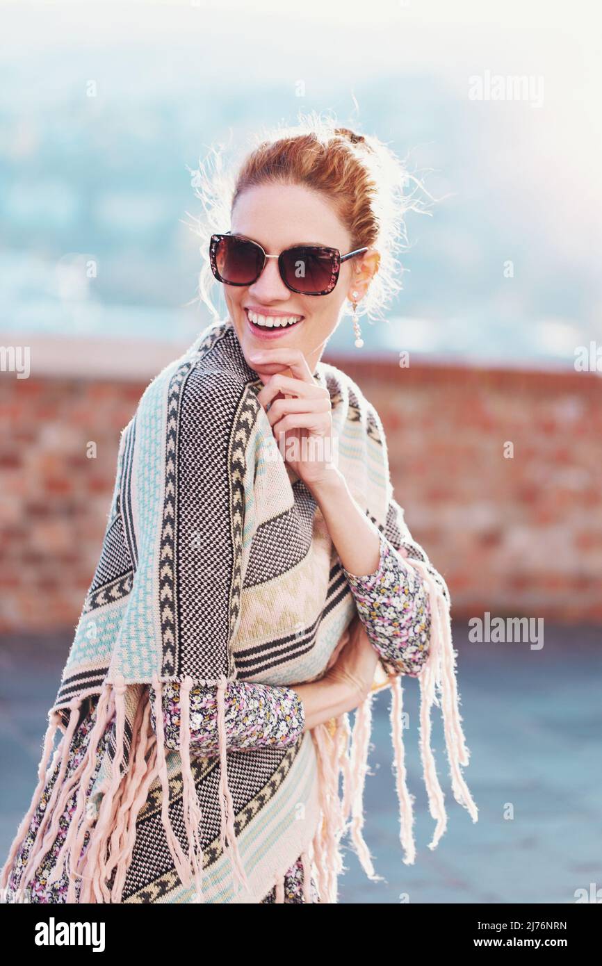 Happy young cheerful woman in poncho and sunglasses have fun outdoors Stock Photo