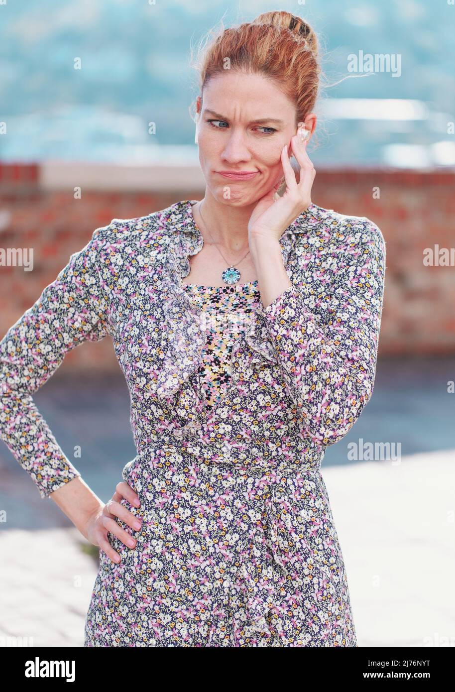 Young redhead sceptic woman make face while calling Stock Photo