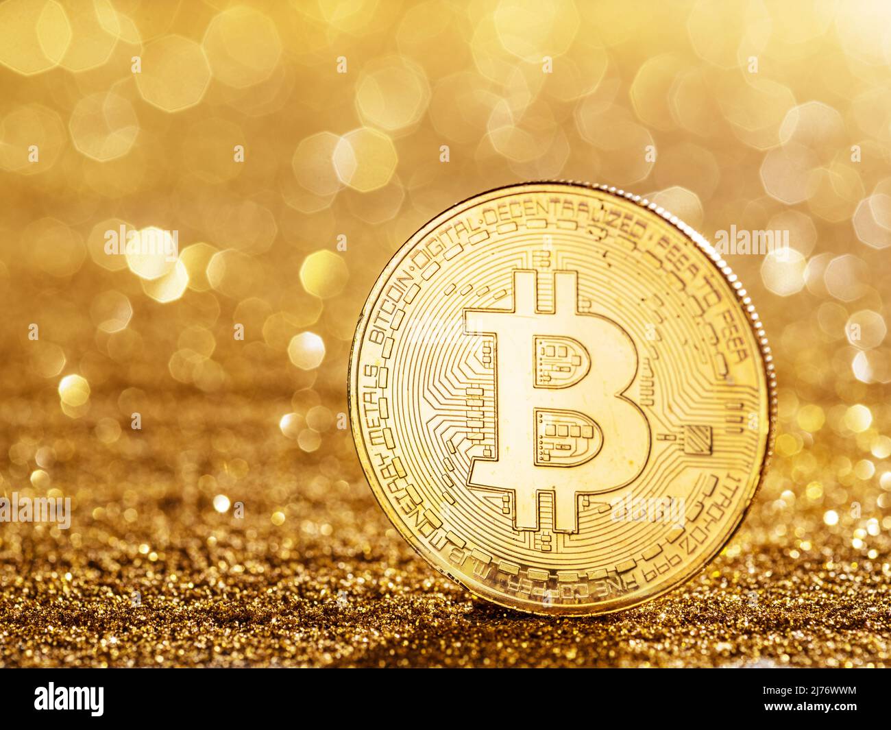 Gold bitcoin coin at the blazing gold background. Conceptual picture of digital money. Stock Photo