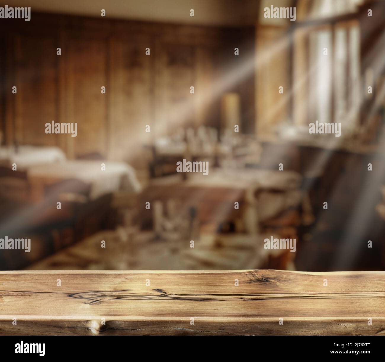 Old wooden table top and blurred rural cafe interior at the background ...