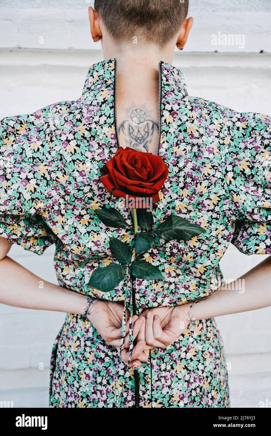 Back view of woman with tattoo Ukrainian trident symbol holds a red rose in  her hands. Ukrainian female volunteer, patriotism, Ukraine will win Stock  Photo - Alamy