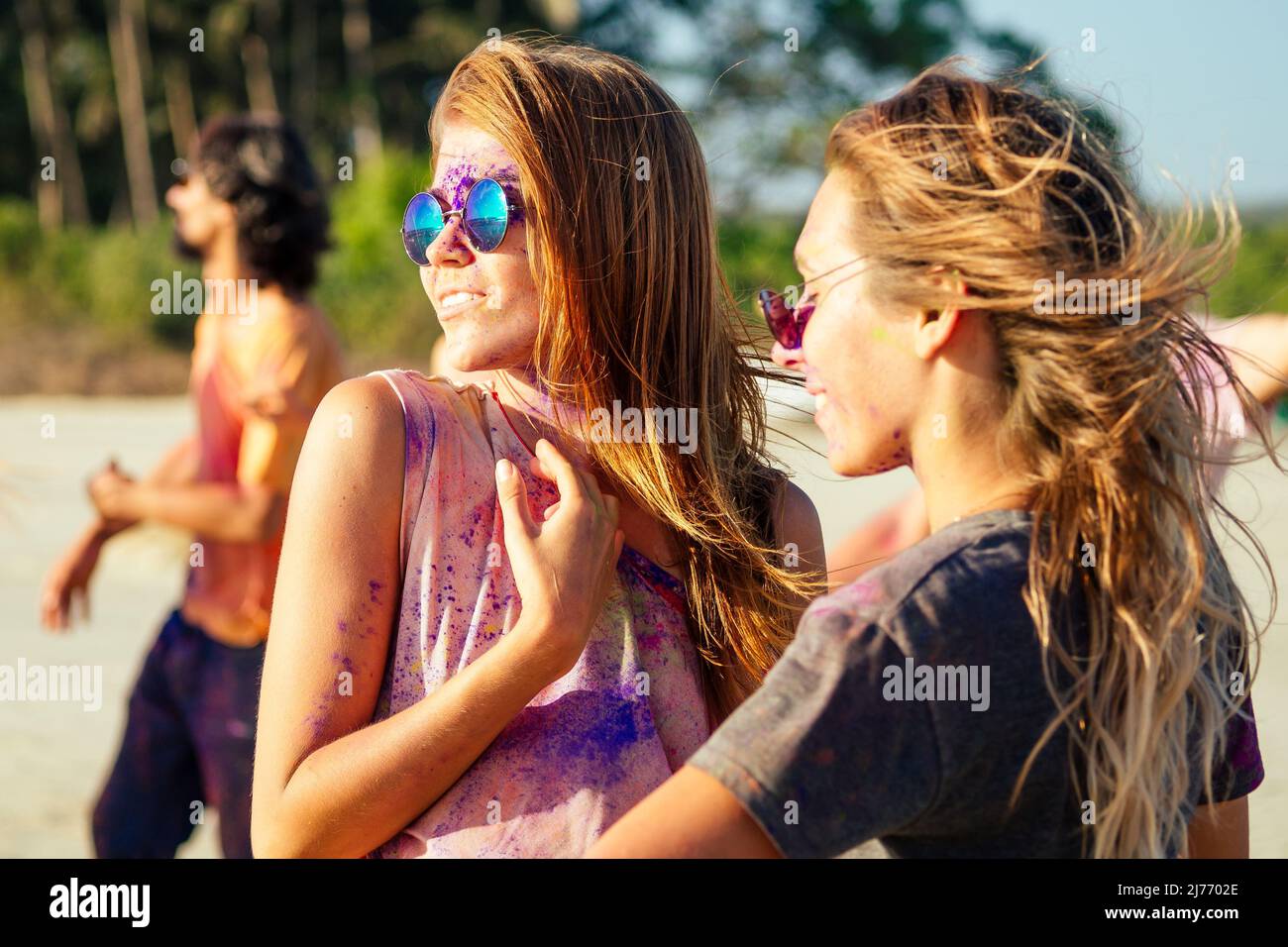 happy people in colorful holi paint play on beach on festive in Goa beach India Stock Photo