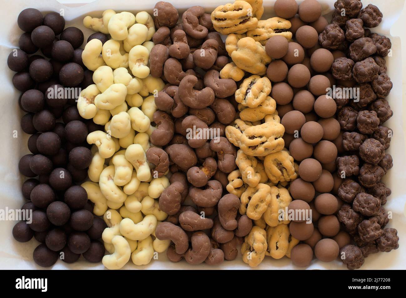 Six types of chocolate covered nuts in vertical rows. Stock Photo