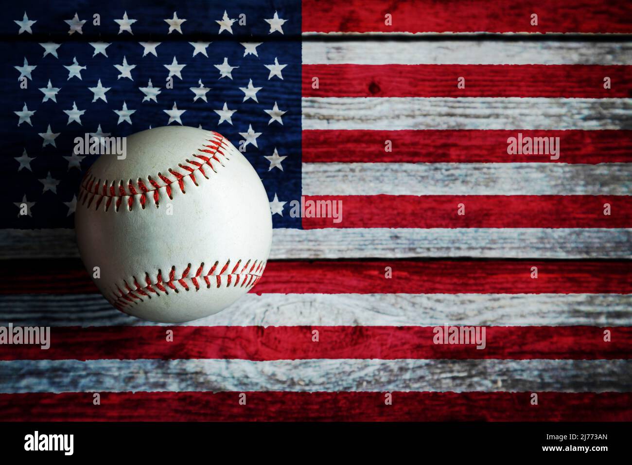 Leather baseball on rustic wooden background painted with US flag with copy space. Stock Photo