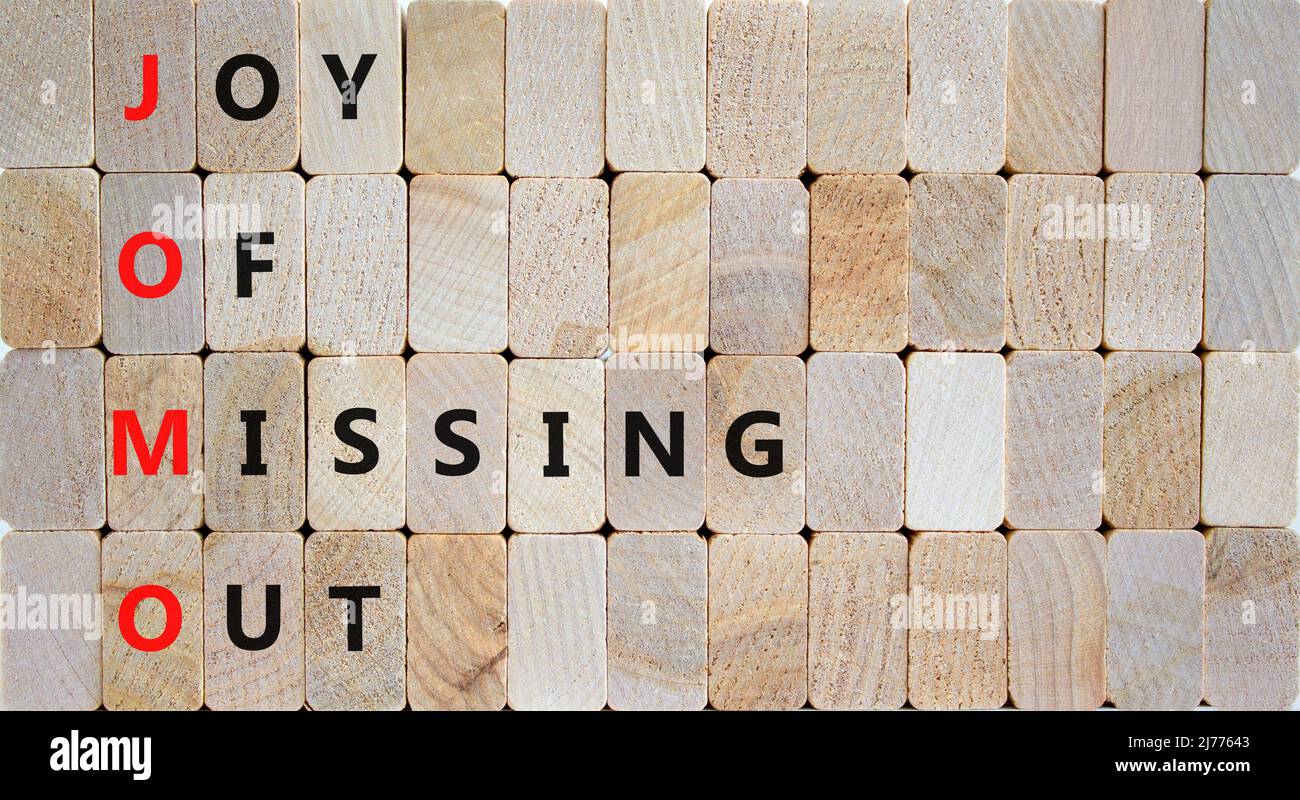 JOMO joy of missing out symbol. Concept words JOMO joy of missing out on wooden blocks on beautiful wooden background. Business JOMO joy of missing ou Stock Photo