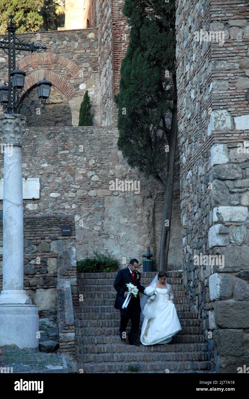 recien casados bajando las escalinatas de la alcazaba  tras realizar los posados para el tradicional reportaje de los novios. Málaga. Stock Photo