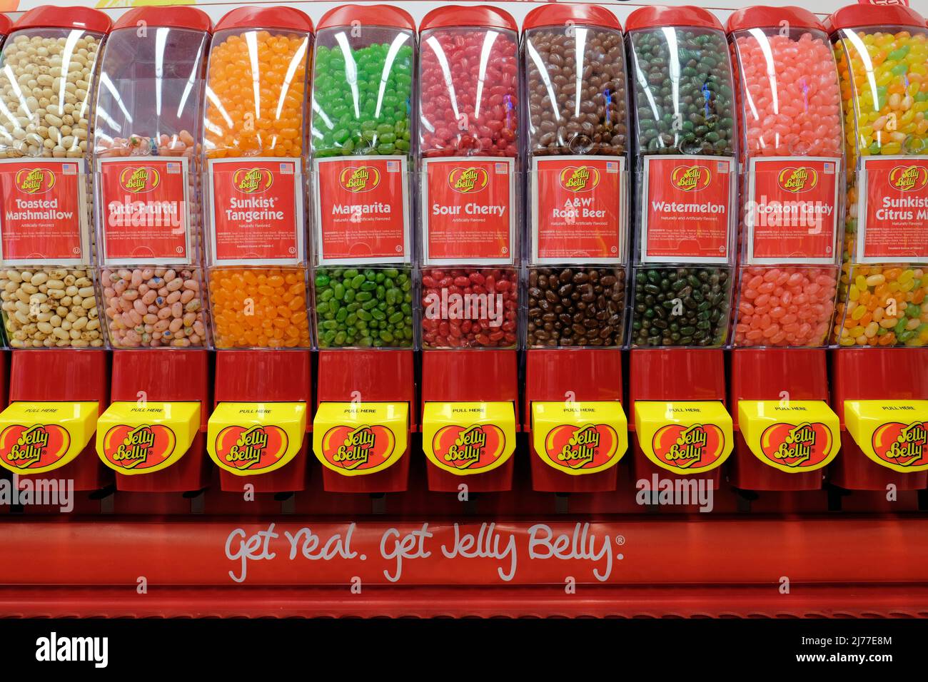 A Jelly Belly brand jelly bean dispenser with assorted flavors for sale by the pound at a retail candy store. Stock Photo