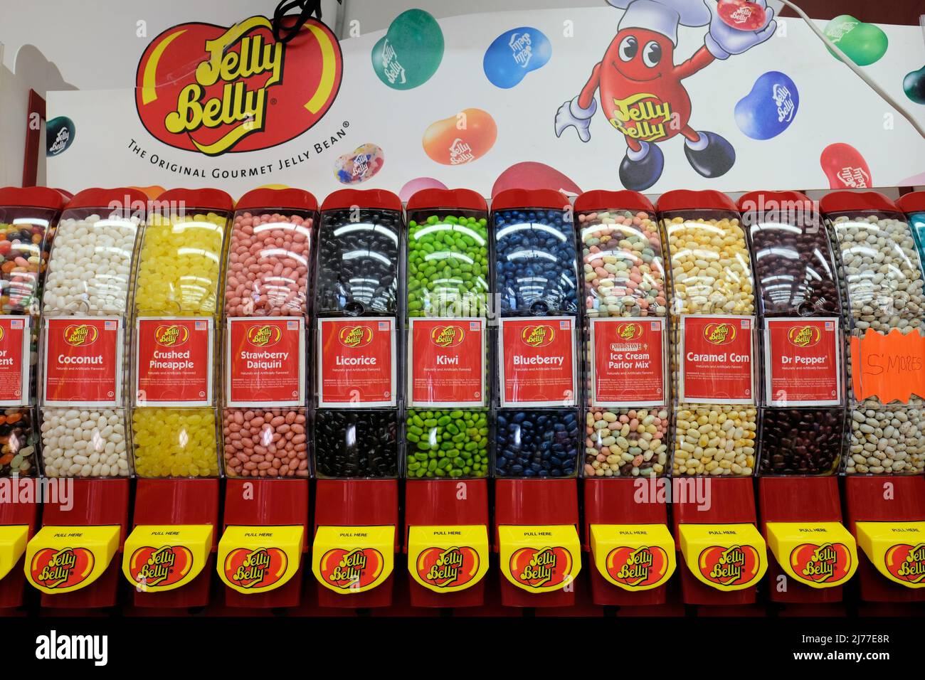 A Jelly Belly brand jelly bean dispenser with assorted flavors for sale by the pound at a retail candy store. Stock Photo