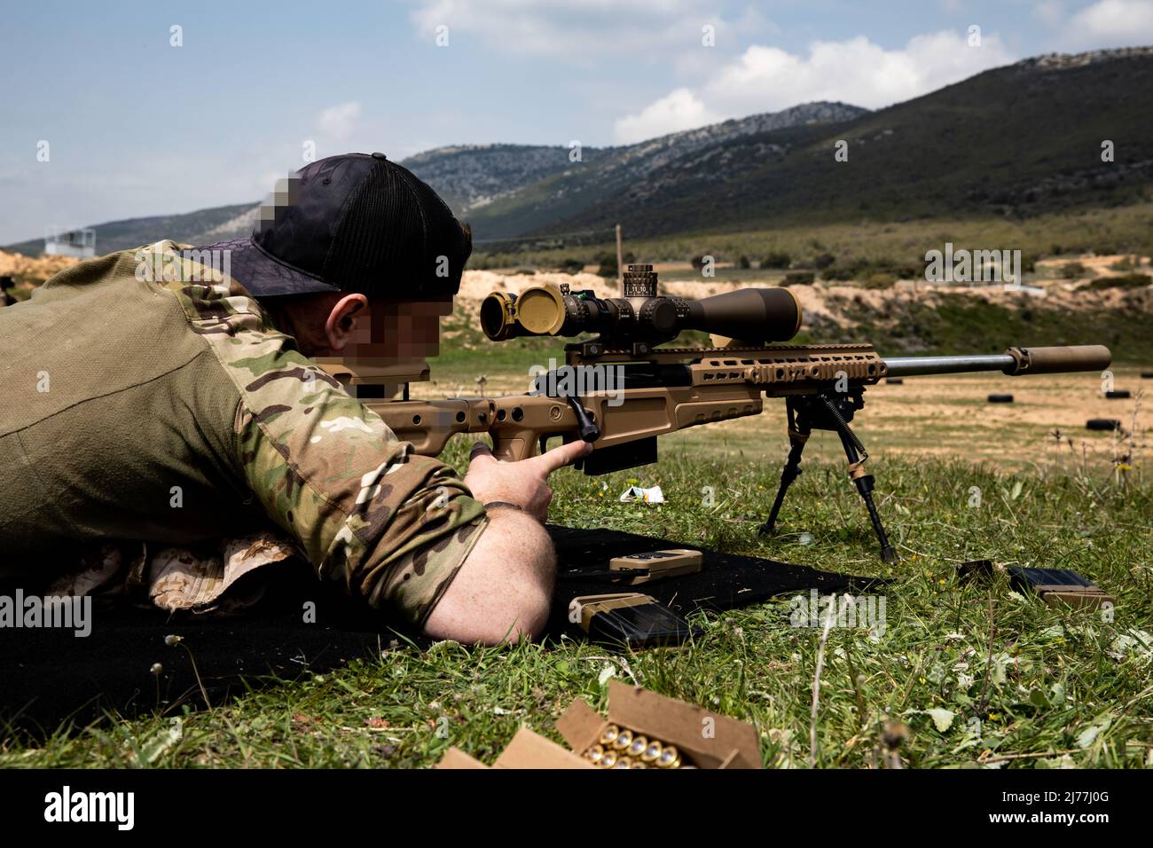 A U.S. Navy SEAL sniper from Naval Special Warfare Group 2 looks through the scope of his rifle at the Greek Z’ Moira Amfivion Katadromon (ZMAK) Special Forces Training Center in preparation for Exercise Orion in the mountains of Greece, March 29, 2022. Exercise Orion reinforces Greece as a regional Special Operations Forces leader, enhances interoperability across multiple domains, and strengthens relationships with NATO and non-NATO partners. The exercise focuses on highlighting operational capabilities, international collaborations and conventional and hybrid warfare training. (U.S. Army ph Stock Photo