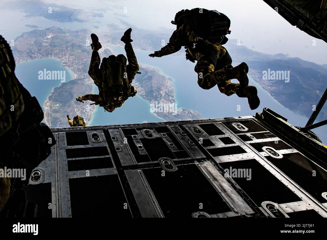Members of Greek Special Forces (SOF) prepare for Exercise Orion as they jump from the ramp of a Greek Air Force C-130 aircraft during airborne operation over a coastal area near Elefsina, Greece, March 30, 2022. Exercise Orion reinforces Greece as a regional SOF leader, enhances interoperability across multiple domains, and strengthens relationships with NATO and non-NATO partners. The exercise focuses on highlighting operational capabilities, international collaborations and conventional and hybrid warfare training. (U.S. Army photo by Sgt. Hannah Hawkins) Stock Photo