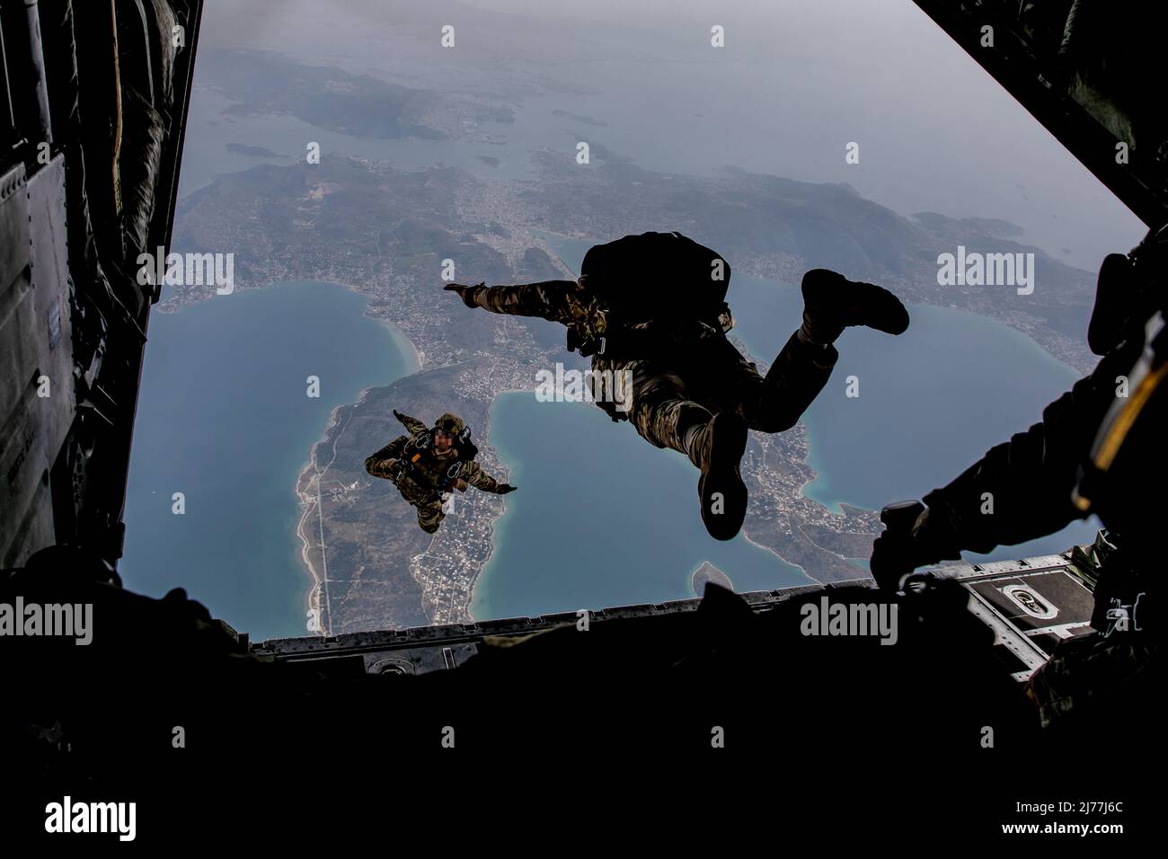Members of Greek Special Forces (SOF) prepare for Exercise Orion as they jump from the ramp of a Greek Air Force C-130 aircraft during airborne operation over a coastal area near Elefsina, Greece, March 30, 2022. Exercise Orion reinforces Greece as a regional SOF leader, enhances interoperability across multiple domains, and strengthens relationships with NATO and non-NATO partners. The exercise focuses on highlighting operational capabilities, international collaborations and conventional and hybrid warfare training. (U.S. Army photo by Sgt. Hannah Hawkins) Stock Photo