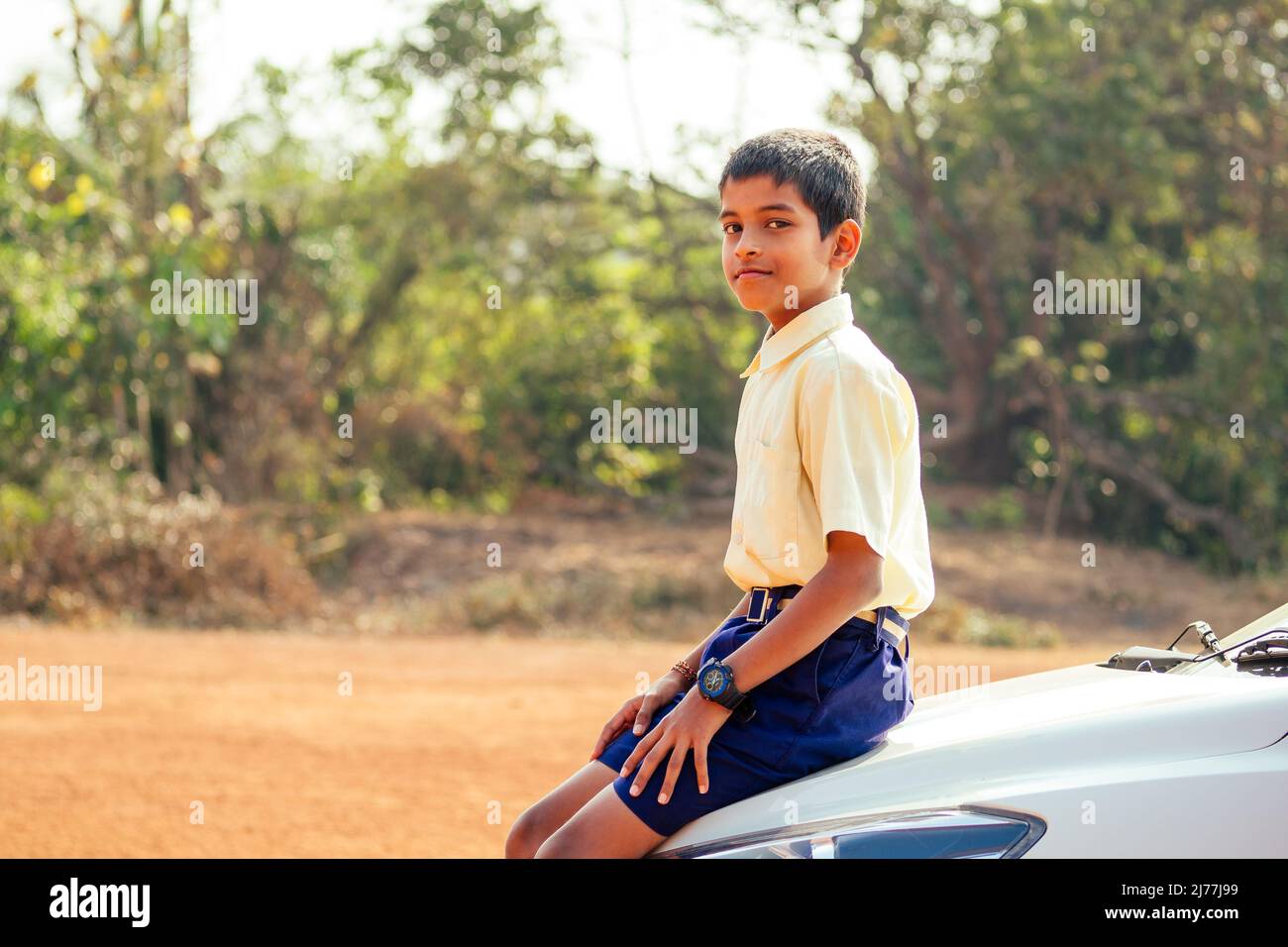 indian smart boy arms crossed looking at camera in backyard Stock Photo