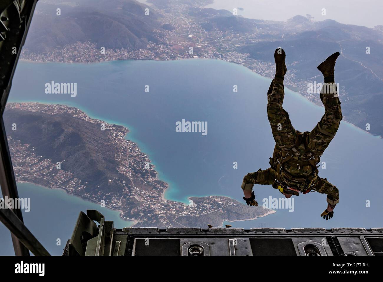 In preparation for Exercise Orion, a U.S. Army Green Beret assigned to 10th Special Forces Group dives from the ramp of a Greek Air Force C-130 aircraft during an airborne operation over a coastal area near Elefsina, Greece, March 30, 2022. Exercise Orion reinforces Greece as a regional Special Operations Forces leader, enhances interoperability across multiple domains, and strengthens relationships with NATO and non-NATO partners. The exercise focuses on highlighting operational capabilities, international collaborations and conventional and hybrid warfare training. (U.S. Army photo by Sgt. H Stock Photo