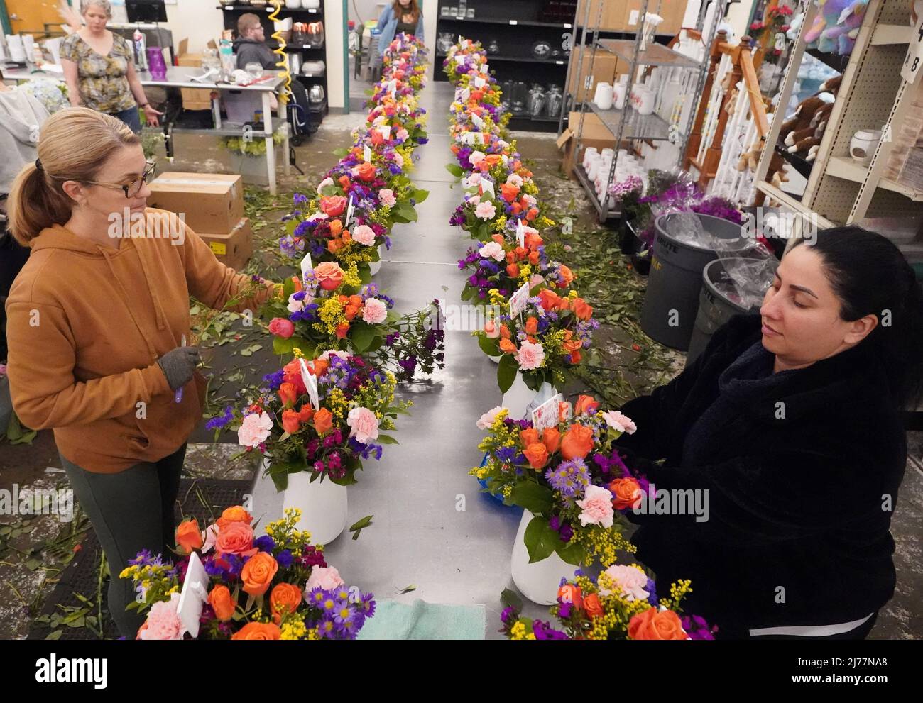 Floral arrangers prepare flowers in all colors for arrangements for