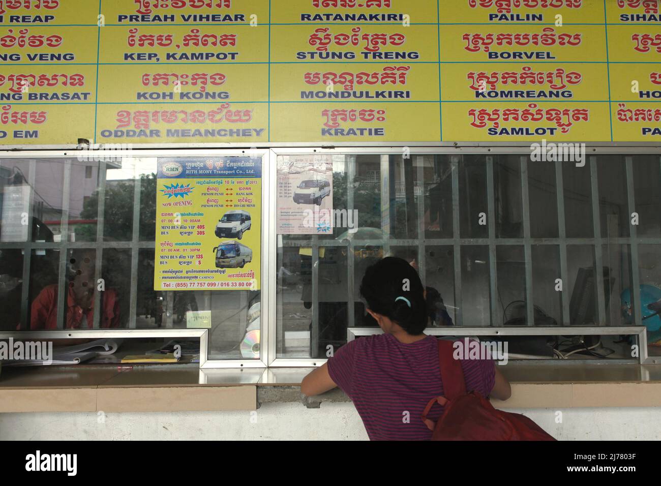 A woman buying bus ticket at the ticket counter of an intercity bus station in Phnom Penh, Cambodia. Stock Photo