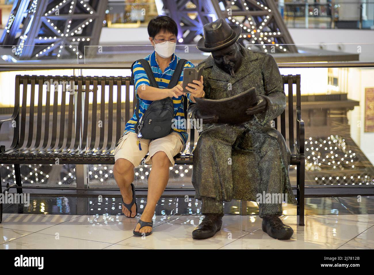 Selfie with famous people. Woman taking selfie photograph alongside a reading statue of Winston Churchill Stock Photo